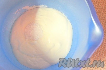 Прежде всего замесим песочное тесто для торта "Избушка". Сливочное масло для замешивания теста должно быть комнатной температуры, поэтому из холодильника его нужно достать заранее, чтобы оно успело согреться и стало мягким. В небольшую миску выложить 200 грамм сметаны, добавить разрыхлитель, перемешать.