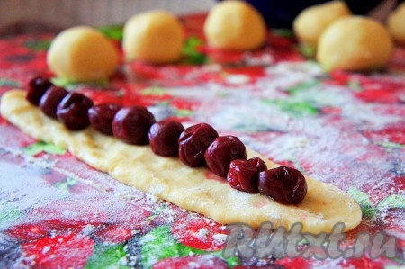 Из каждой части раскатать прямоугольник (старайтесь, чтобы все прямоугольники были одинакового размера). На раскатанный прямоугольник в длину плотно друг к другу выложить вишню (см. фото) и аккуратно, тщательно защипнуть длинные края прямоугольника над начинкой. Сформированную "колбаску" выложить швом вниз на противень, застеленный ковриком (или бумагой) для выпечки. Аналогично ещё из 5-6 частей песочного теста сформировать "колбаски" с начинкой из вишни, выкладывая их швом вниз на расстоянии друг от друга на застеленный противень. Советую формировать одновременно столько "колбасок", сколько поместится на противень. У меня на противень одновременно поместились 7 колбасок, именно столько я и сформировала.