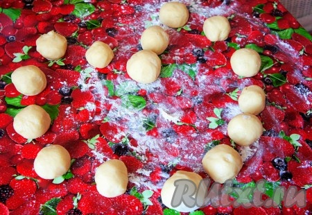 Если вишня заморожена и на ней много льда, тогда её нужно полностью разморозить, удаляя лишнюю жидкость. Вишню, на которой мало льда, можно не размораживать. Если же ягоды свежие, тогда вымойте их, косточки удалите, выделившийся сок слейте. Рабочую поверхность хорошо присыпать мукой, тесто извлечь из пакета, обмять его немного, затем разделить на 15 частей - "шариков".