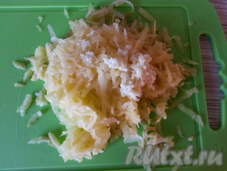 Натираем на крупной терке половину манго, сверху выдавливаем чеснок.
