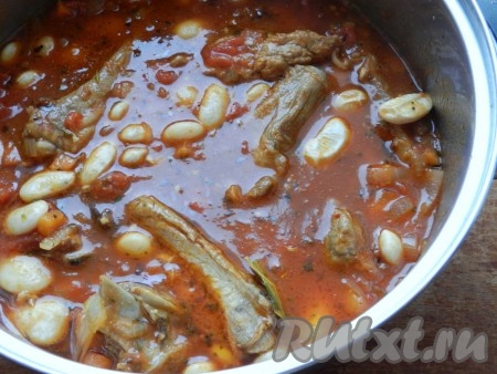Выложить варёную фасоль, перемешать, довести до кипения, уменьшить огонь. Накрыть крышкой и тушить фасоль со свиными рёбрышками на очень медленном огне 45-50 минут. Мясо должно стать мягким.