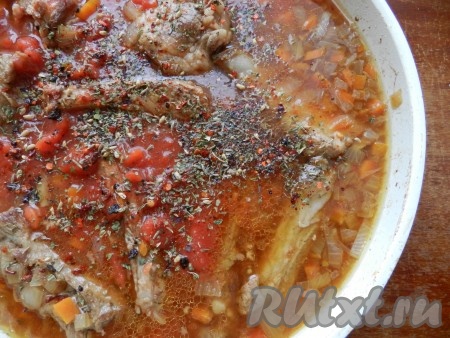 В отдельную ёмкость влить 200 миллилитров воды, добавить томатную пасту, перемешать, вылить в сковороду, добавить соль, пропущенный через пресс чеснок, специи (в качестве специй я использовала чёрный молотый перец и смесь специй "Для шурпы", в состав которой входят кориандр, паприка, чабер, зира, острый перец, базилик, петрушка, укроп), перемешать. Жидкость должна покрывать свиные рёбрышки практически полностью. Довести получившийся соус до кипения.