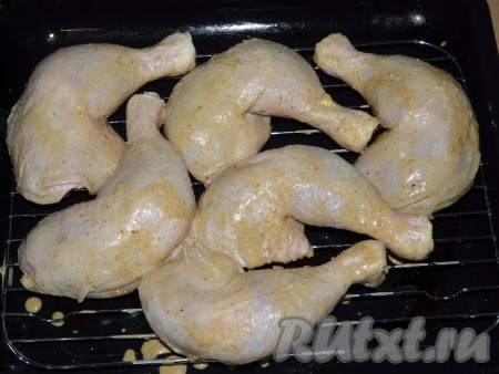 На противень поставить решетку и выложить куриные ножки. Поставить в предварительно нагретую духовку.
