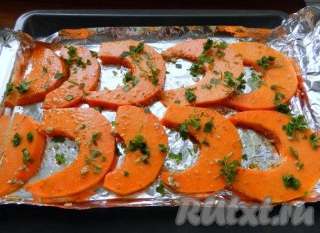 Свежую зелень (у меня - петрушка) вымыть, немного обсушить, мелко нарезать. Посыпать тыкву зеленью. Накрыть противень фольгой, закрутив её по краям. Поставить тыкву в разогретую до 200 градусов духовку на 15-20 минут. Затем фольгу раскрыть и запекать ещё 5-7 минут (можно под грилем). Тыква должна стать мягкой и легко прокалываться зубочисткой. Продолжительность запекания во многом зависит от сорта тыквы. Поэтому если тыква ещё не стала достаточно мягкой, запекайте её ещё в течение 5-10 минут (до мягкости).