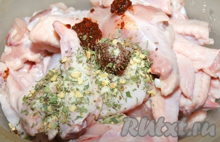 Куриные крылья разрезать по суставам. Самую тонкую часть я не использую, на ней одна кожа и кости. Сложить разрезанные на суставы кусочки крылышек в миску, добавить аджику, соль и специи по вкусу. Я использовала аджику в виде пасты. Такая аджика продается в магазинах и на рынках.
