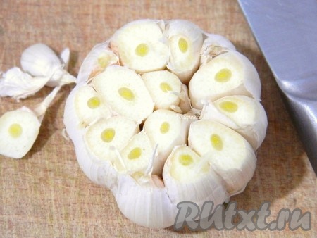 Барем головку чеснока и срезаем у нее верхушку.