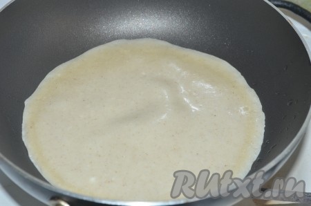 На раскалённую сковороду (перед выпечкой первого блина можно слегка смазать сковородку маслом) налить половник теста, равномерно распределить. Выпекать блин с припёком из творога, как обычный блинчик, до золотистого цвета с двух сторон на среднем огне, затем переложить на тарелку.