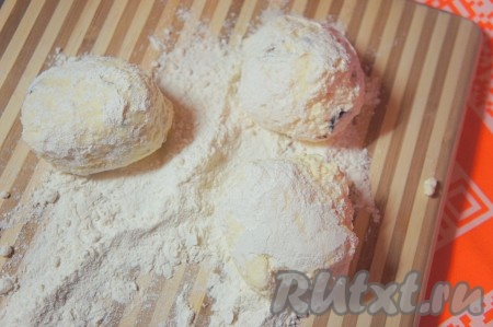 На рабочую поверхность просеять муку. Слегка влажными руками сформировать из творожной основы шарики, обвалять их в муке.