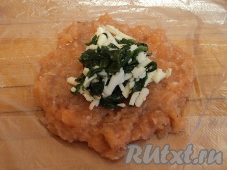 Для начинки шпинат обжарить на сливочном масле с щепоткой соли и перца,&nbsp;и смешать с натертым сыром.
Фарш из лосося получается очень мягким, поэтому для формирования котлет нам понадобится пищевая пленка. Кусок пленки положить на ладонь или стол и выложить фарш, хорошо распределить по столу или ладони.
