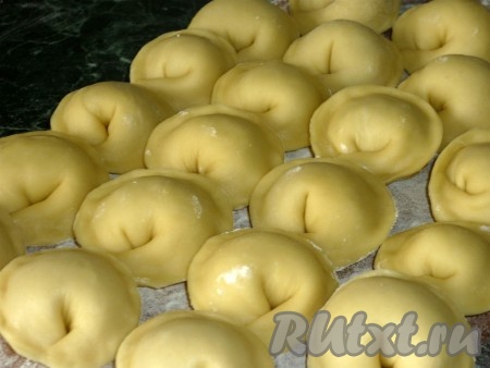 Повторяем эту процедуру, формируя пельмени, пока не закончатся тесто и фарш из свинины. Выкладываем слепленные пельмени на немного припылённую мукой доску. Часть пельменей можно сразу отварить, а часть заморозить в морозилке. Для заморозки доску с пельменями нужно отправить в морозилку, а когда пельмени заморозятся, переложить их в целлофановый пакет и отправить на хранение в морозилку.