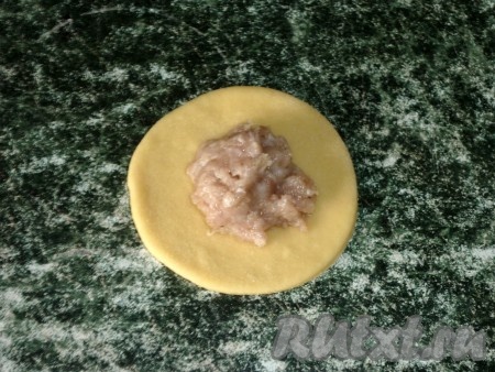 В центр каждого кружка из теста выложить 1 чайную ложку фарша из свинины.