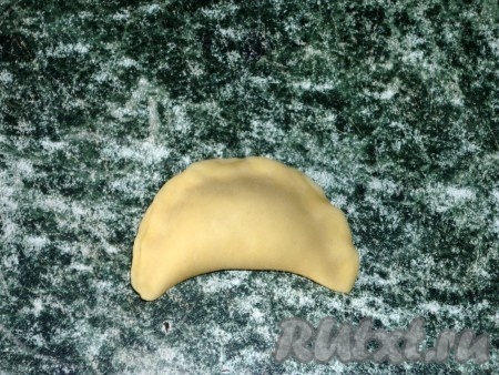 Согнуть кружок с фаршем пополам и защипнуть края.