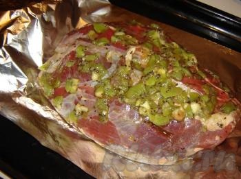 По прошествии времени достать мясо и завернуть его в фольгу вместе с крупными кусочками киви.