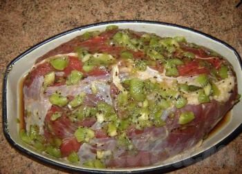 Киви промыть, очистить от кожуры и нарезать небольшими дольками. Целый кусок свинины промыть в холодной воде, посолить и поперчить по вкусу. По всей поверхности мясного кусочка сделать надрезы-кармашки. В каждый "кармашек" вложить дольку киви. Сверху обмазать кусочек мяса оставшейся мякотью киви.