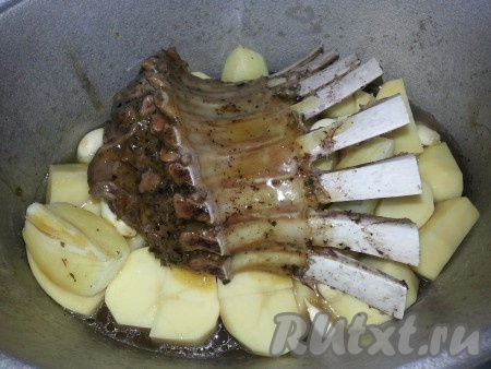 Смешиваем мёд с горчицей, обмазываем ребра и немного открытые части картофеля, лука. Если на дне утятницы осталось мало вды, подлейте ещё немного водички.