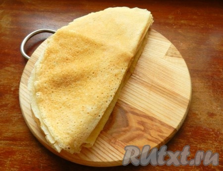 Готовые блины разрезать на две части.