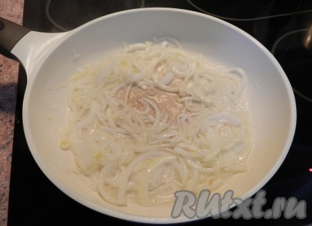 В сковороду влить растительное масло, выложить нарезанный полукольцами лук и обжарить его на среднем огне, помешивая, до прозрачности.