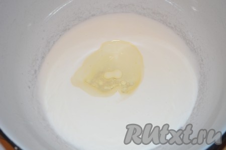 В миску влить кефир комнатной температуры (я подогреваю кефир до комнатной температуры в течение 20 секунд в микроволновке, но, если время позволяет, можно просто достать его заранее из холодильника), добавить 1 столовую ложку растительного масла, перемешать.