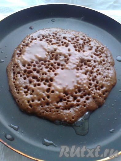 Подогреть молоко до теплого, растопить масло. Смешать жидкие компоненты (молоко, яйца, сливочное масло) отдельно, сухие (мука, какао, сахар, соду) - отдельно. Влить жидкие компоненты в сухие, перемешать. Покрошить шоколад не очень мелко, перемешать (я не добавляла). Выпекать шоколадные оладьи на разогретой блинной сковороде, смазав её 1 чайной ложкой подсолнечного масла.
