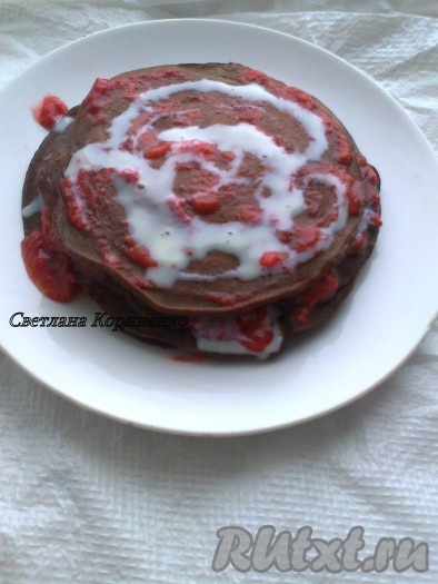 Переложить оладьи клубникой, порезаной тонкими пластинками. Сверху посыпать сахарной пудрой и украсить целыми ягодами. Мои изменения: шоколада и свежей клубники у меня не было, поэтому оладьи переложила мороженой клубникой с сахаром и невареным сгущенным молоком.
