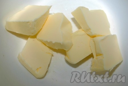 На этом этапе можно кексы оставить и в таком виде подавать на стол. А можно приготовить глазурь из сливочного масла и ею смазать верхушки кексов. Если вы решите приготовить масляную глазурь, то для этого надо нарезать масло небольшими кусочками, поместить их в миску.
