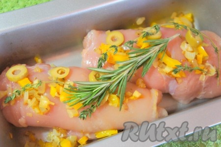 Духовку разогреть до 180 градусов. Форму смазать оливковым маслом, выложить рулеты из курицы в форму. Если останется овощная начинка, то выложите её сверху рулетов. Сверху положите нарезанные оливки, веточки розмарина и тимьяна.