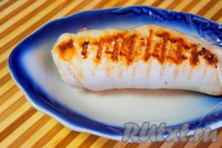 На один край отбитого куска куриного филе выложить плавленный сыр, а затем свернуть мясо плотным рулетом и обжарить его на гриле (можно обжарить на обычной сковороде с добавлением небольшого количества масла).