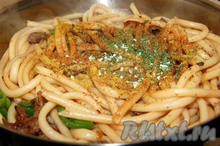Горячие макароны  выложить в сковороду с мясом и овощами. Добавить соль, перец, специи.