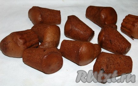 Формочки с готовыми шоколадными кексами с изюмом достать из духовки, дать немного стыть, а затем вынуть из формочек и остудить на столе.