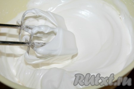 Белки взбить в пену, затем добавить постепенно сахарную пудру и взбивать до состояния твердых пиков, чтобы взбитые белки не спадали с ложки.