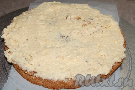 Смазать кремом нижний корж торта.
