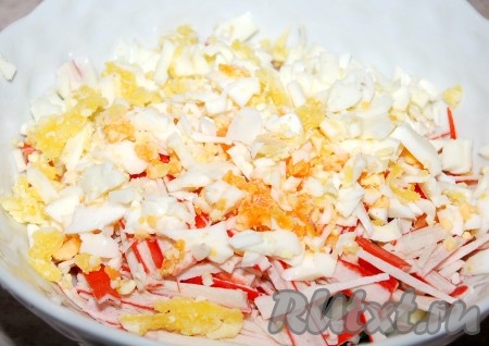 Яйца отварить вкрутую (в течение минут 8-10 с начала кипения воды), остудить, очистить, нарезать достаточно мелко и добавить в миску с огурцом и крабовыми палочками.