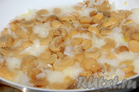 Шампиньоны нарезать на достаточно тонкие пластины (у меня консервированные шампиньоны). Очищенную луковицу мелко нарезать. Нарезанные лук и шампиньоны выложить на сковороду, разогретую с растительным маслом, и обжарить до мягкости лука (в течение минут 5-6).