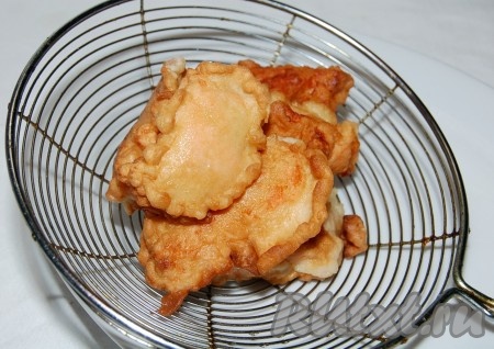 Обжаренные кусочки рыбы выложить на сито, чтобы стекло лишнее масло.
