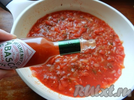 Очистить и обжарить вторую луковицу с оставшимся чесноком. Выложить к луку помидоры из банки, добавить соль, перец, специи и томатную пасту. Осторожно добавить острый соус табаско.