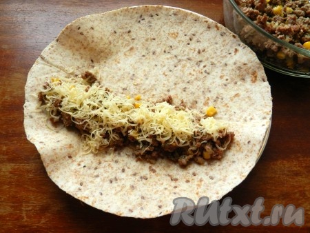 На лепешку тортилья выложить начинку из фарша, присыпать натертым на мелкой терке сыром.