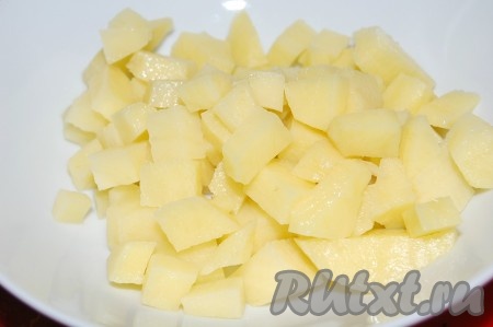 Сначала нужно сварить куриный бульон. Части курицы промыть водой, переложить в кастрюлю, влить 2 литра холодной водой и поставить на огонь. Довести до кипения, снять пену, уменьшить огонь и варить 35-40 минут. Убрать с огня, достать мясо из бульона. Бульон, если необходимо, процедить и вернуть в кастрюлю. Кастрюлю с бульоном поставить на огонь, дать закипеть. Пока куриный бульон закипает, нужно очистить и нарезать на небольшие кубики картофель.