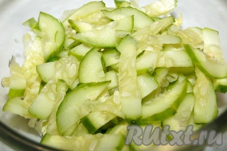 Свежий огурец нарезать небольшими кусочками и добавить в миску.