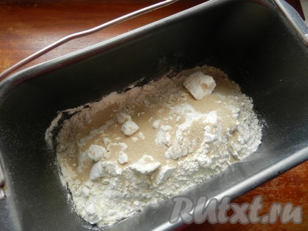 Поместить ингредиенты в контейнер хлебопечки в том порядке, в каком предусмотрено инструкцией. Для хлебопечки "Мулинекс" (Moulinex) ингредиенты закладываются, начиная с жидкостей: тёплая вода, растительное масло, соль, сахар, сухое молоко, пшеничная и ржаная мука, сухие дрожжи. Вода должна быть именно тёплой, а не горячей, её температура не должна быть выше 40 градусов.