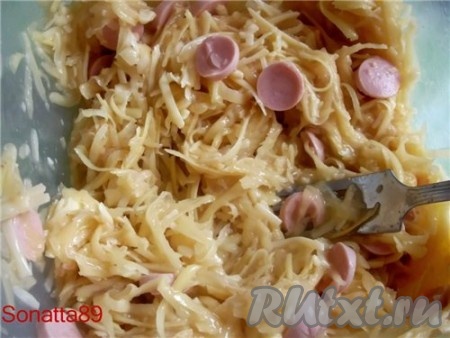 В миску с сыром, картофелем, сосисками раскалываем 2 яйца, солим, перчим и все перемешиваем.
