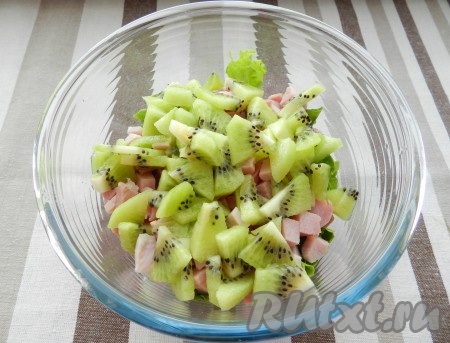 Листья салата нарезать или порвать руками, сложить в салатник, добавить нарезанное мясо и киви, перемешать.