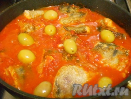 Когда соус с помидорами в собственном соку протушится минут 15, выложить в него обжаренные кусочки рыбы. Сюда же влить по вкусу томатный сок из банки помидоров в собственном соку, по желанию, добавить оливки, если нужно, подсолить соус по вкусу. Дать соусу закипеть, накрыть сковороду крышкой  и тушить рыбку 10-15 минут.
