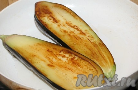 Обе половинки баклажана обжарить на растительном масле на сковороде на среднем огне до румяности и мягкости с двух сторон.