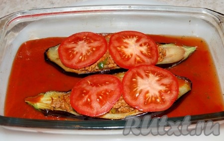 Вылить в форму томатную заливку, а на лодочки из баклажанов выложить кружочки помидоров. Разместить форму с лодочками в заранее нагретую до 200 градусов духовку и запекать 15-25 минут. За это время заливка почти полностью выпарится, станет густой, а баклажаны - мягкими.