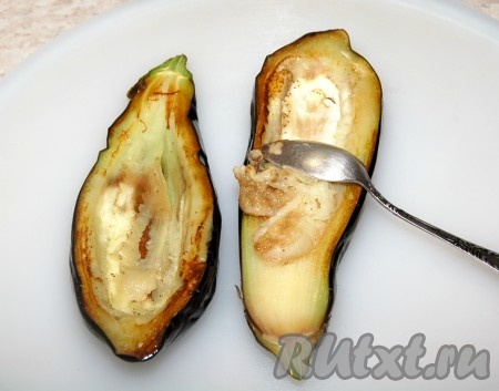 Обжаренные баклажаны выложить на доску и остудить. С помощью ложки вынуть мякоть. Вынутую мякоть не выбрасывайте, мы её добавим в фарш. Получатся полые "лодочки" из баклажанов.