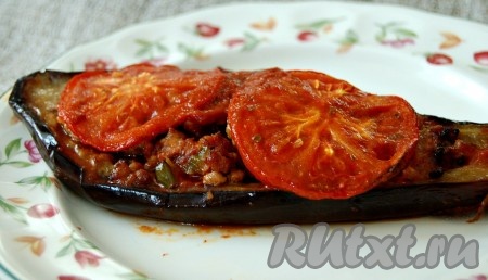 Запечённые лодочки из баклажанов с фаршем достать из духовки, выложить на тарелку и подать на стол.