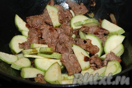 Кабачки нарезать не очень тонкими полукольцами и добавить в сковороду.