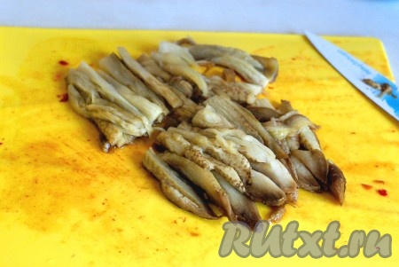 Снять кожицу и нарезать баклажаны полосками.