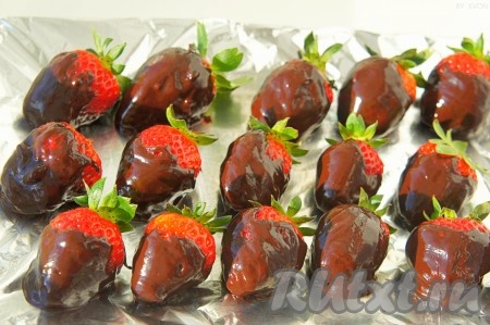 Тарелку предварительно застелите фольгой и выкладывайте клубнику в шоколаде на небольшом расстоянии друг от друга, чтобы ягоды не соприкасались. По желанию, украсьте десерт измельчёнными орешками, кокосовой стружкой, кондитерскими украшениями.