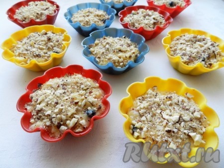 Тесто для маффинов с черникой разложить по формочкам для выпечки на 1/3, сверху посыпать ореховой посыпкой.